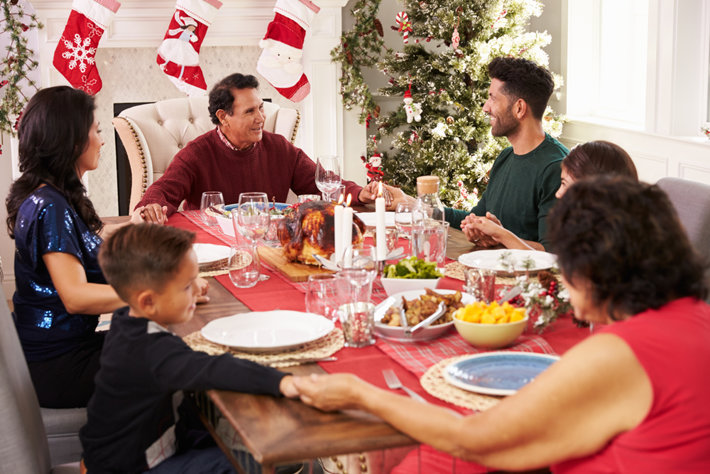 Family is holding hands on Christmas diner