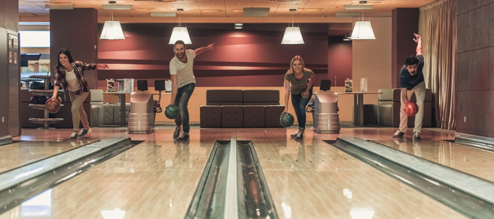 Friends are having fun by playing bowling
